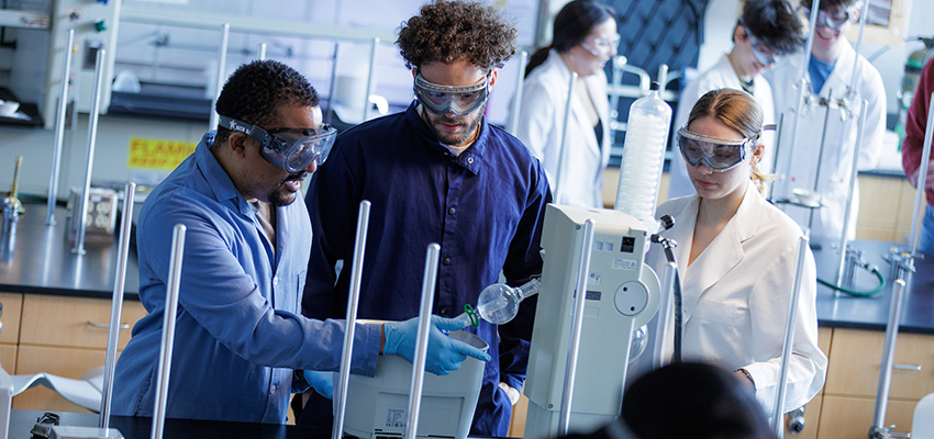 Students and professor in chemistry lab working with equipment